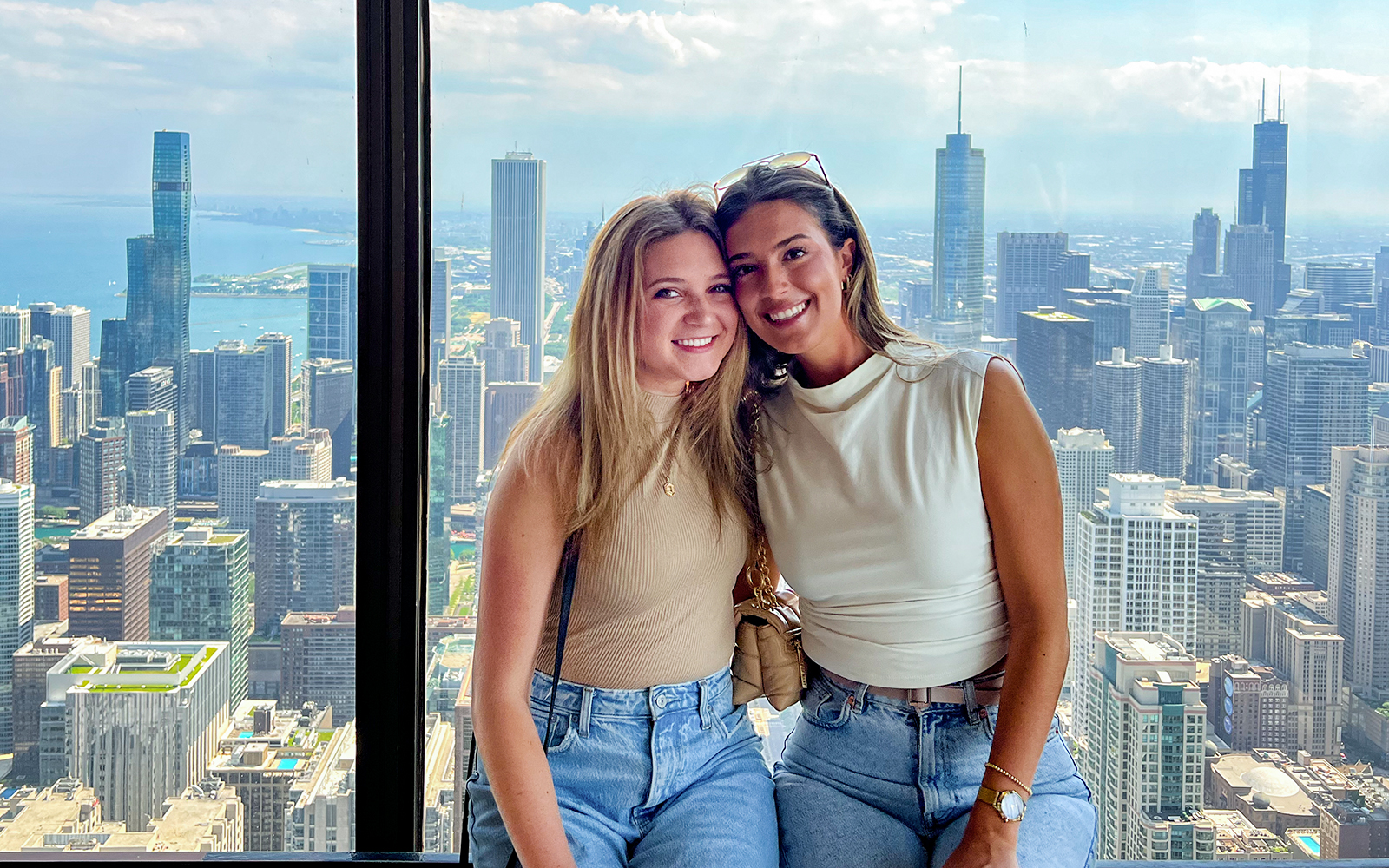 Two people enjoying a view of the Chicago skyline from a high-rise, part of the Sip & View tour.