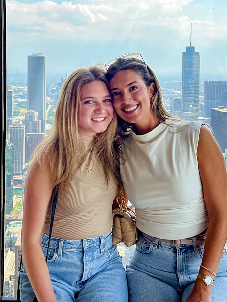 Two people enjoying a view of the Chicago skyline from a high-rise, part of the Sip & View tour.