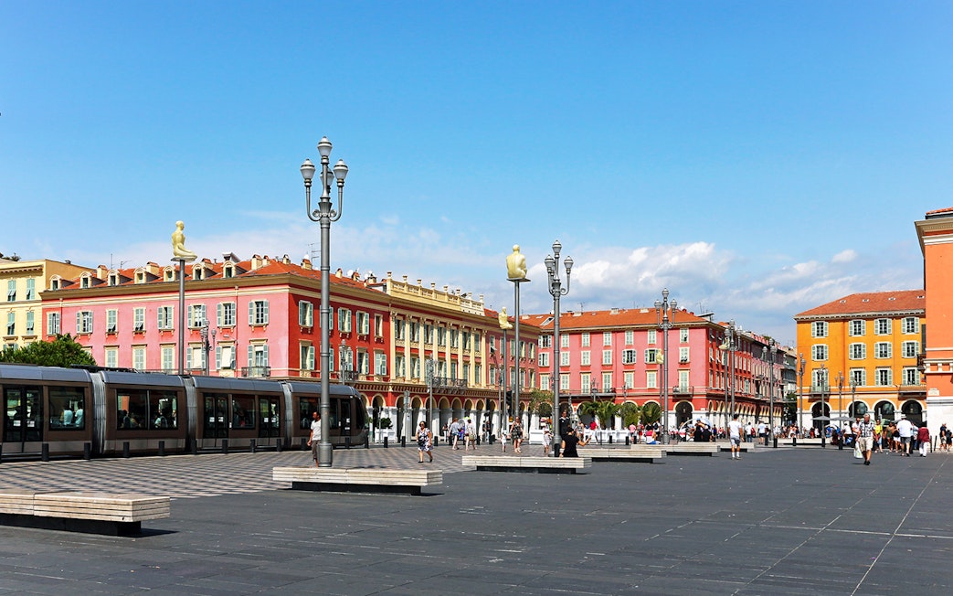Place Masséna in Nice with colorful buildings and tram, part of self-guided audio tour.