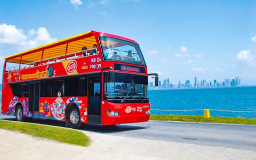 Hop On Hop Off tour bus in Panama City with skyline view.