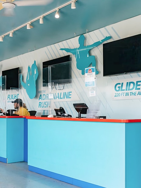 Zipline To The Falls ticket counter with customer and staff interaction.