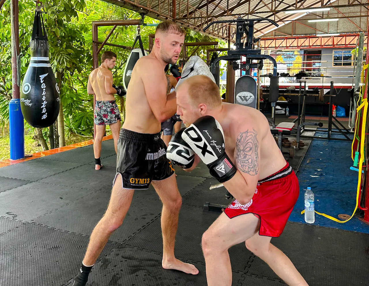 Muay Thai beginners practicing boxing techniques in a Phuket training gym.