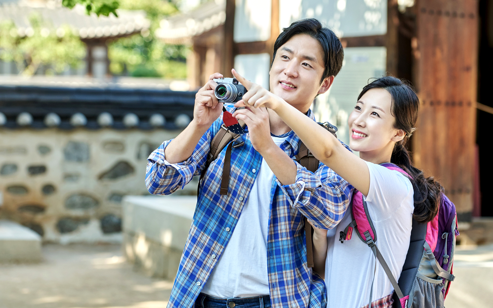 Asian man and woman photographing traditional architecture in Singapore.