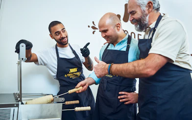 Participants learning to make chimney cakes at a Budapest workshop.