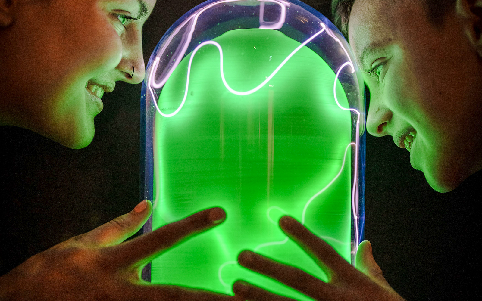 Visitors interacting with a glowing exhibit at Camera Obscura & World of Illusions, Edinburgh.