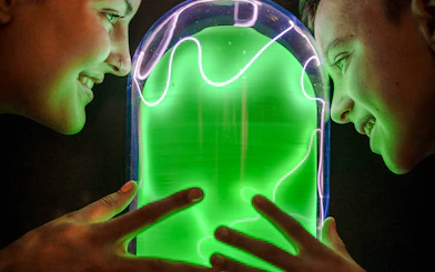 Visitors interacting with a glowing exhibit at Camera Obscura & World of Illusions, Edinburgh.