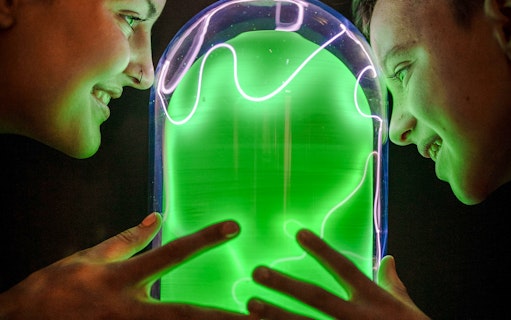 Visitors interacting with a glowing exhibit at Camera Obscura & World of Illusions, Edinburgh.