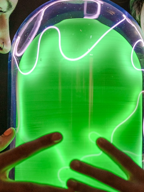 Visitors interacting with a glowing exhibit at Camera Obscura & World of Illusions, Edinburgh.