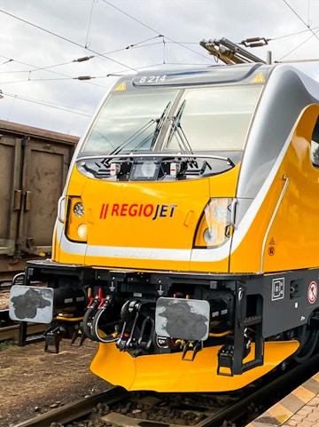 RegioJet train on railway tracks, showcasing modern design and branding.