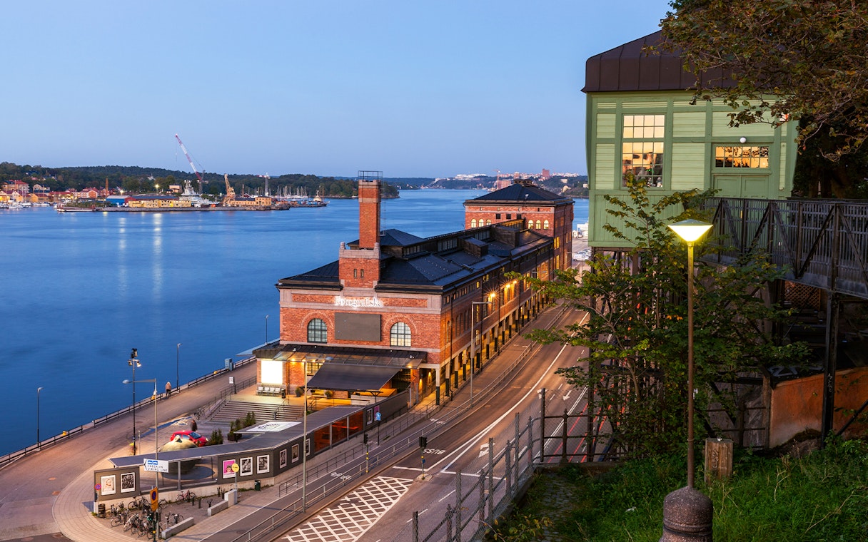 Stockholm waterfront view with historic brick building and distant island.