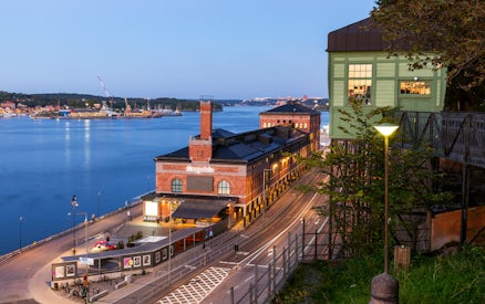Stockholm waterfront view with historic brick building and distant island.