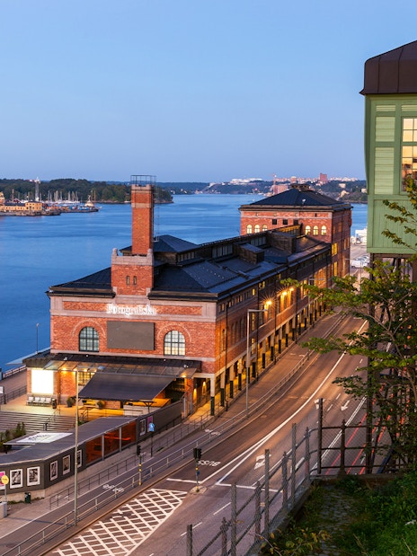 Stockholm waterfront view with historic brick building and distant island.
