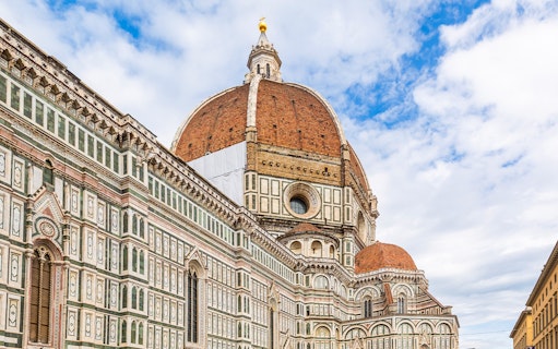 Brunelleschi's Dome viewed from the street in Florence, showcasing intricate architectural details.