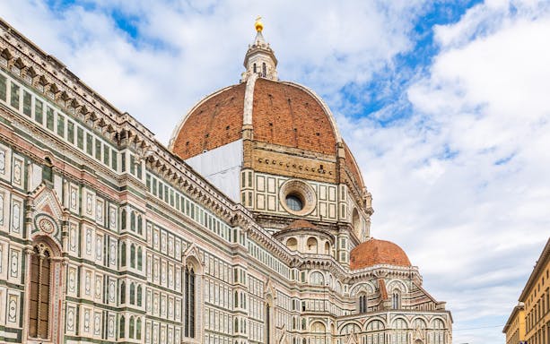 Brunelleschi's Dome viewed from the street in Florence, showcasing intricate architectural details.