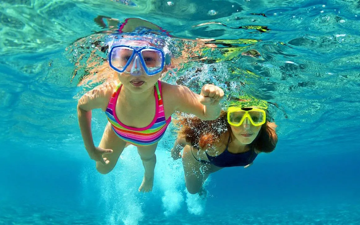 Two people snorkeling in Lake Vouliagmeni, Greece, during a small-group day trip.