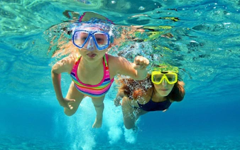 Two people snorkeling in Lake Vouliagmeni, Greece, during a small-group day trip.