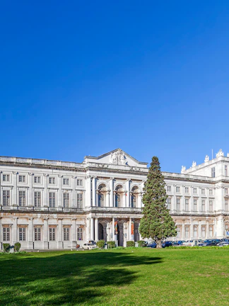 National Palace of Ajuda facade with green lawn in Lisbon, Portugal.
