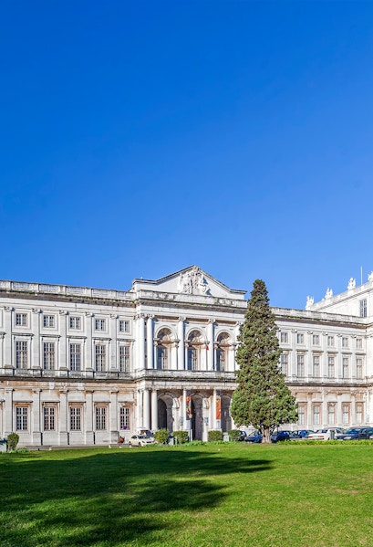 National Palace of Ajuda facade with green lawn in Lisbon, Portugal.