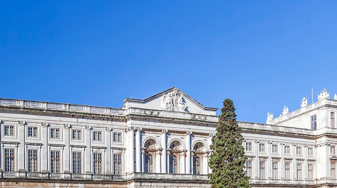 National Palace of Ajuda facade with green lawn in Lisbon, Portugal.
