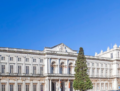 National Palace of Ajuda facade with green lawn in Lisbon, Portugal.