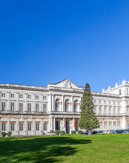 National Palace of Ajuda facade with green lawn in Lisbon, Portugal.