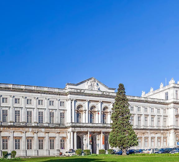 National Palace of Ajuda facade with green lawn in Lisbon, Portugal.
