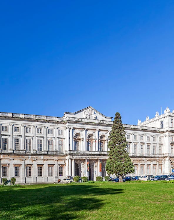 National Palace of Ajuda facade with green lawn in Lisbon, Portugal.
