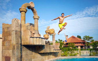 Visitors jumping into a pool at Adventure Cove Waterpark™, Singapore.