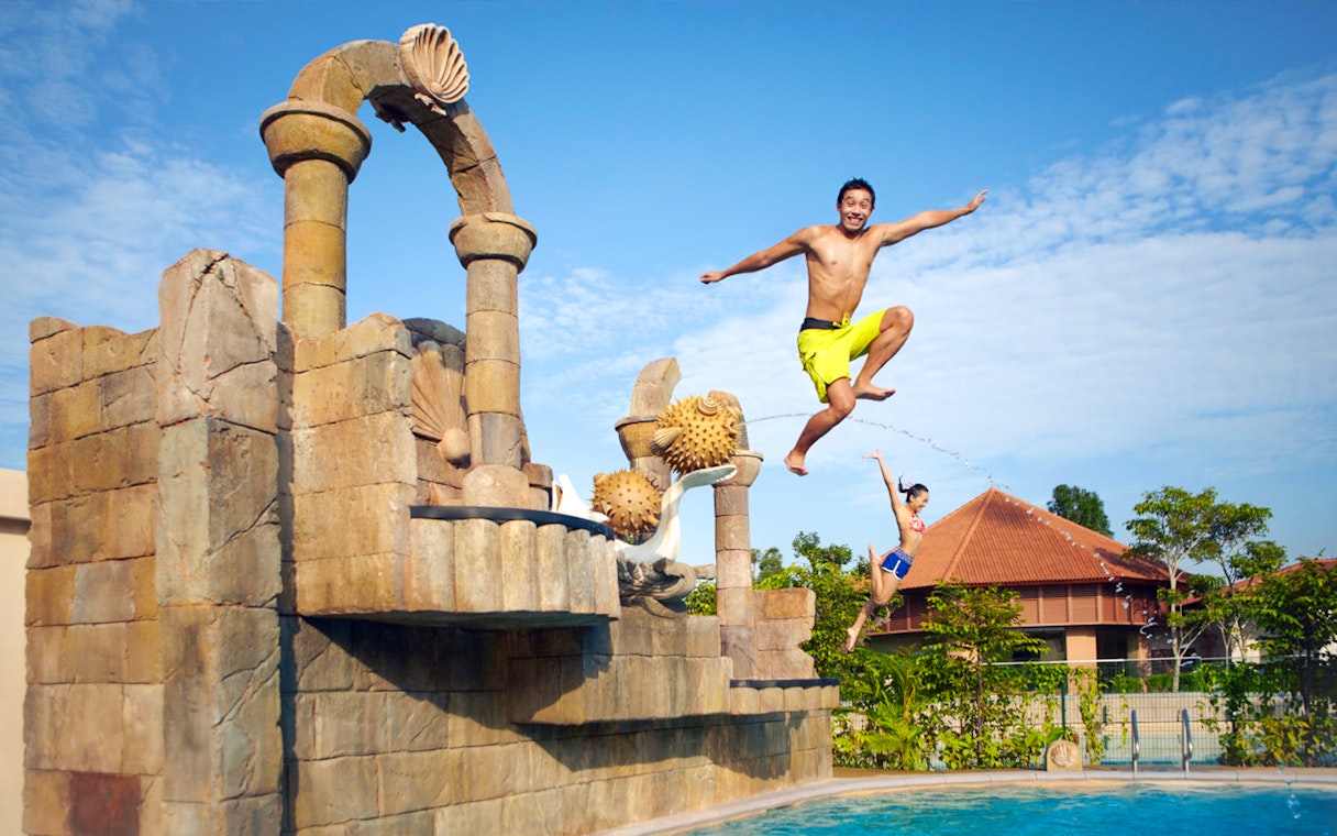 Visitors jumping into a pool at Adventure Cove Waterpark™, Singapore.