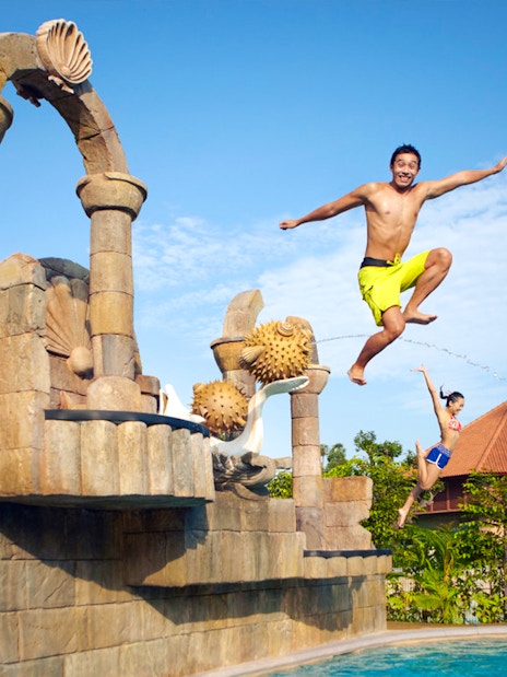 Visitors jumping into a pool at Adventure Cove Waterpark™, Singapore.