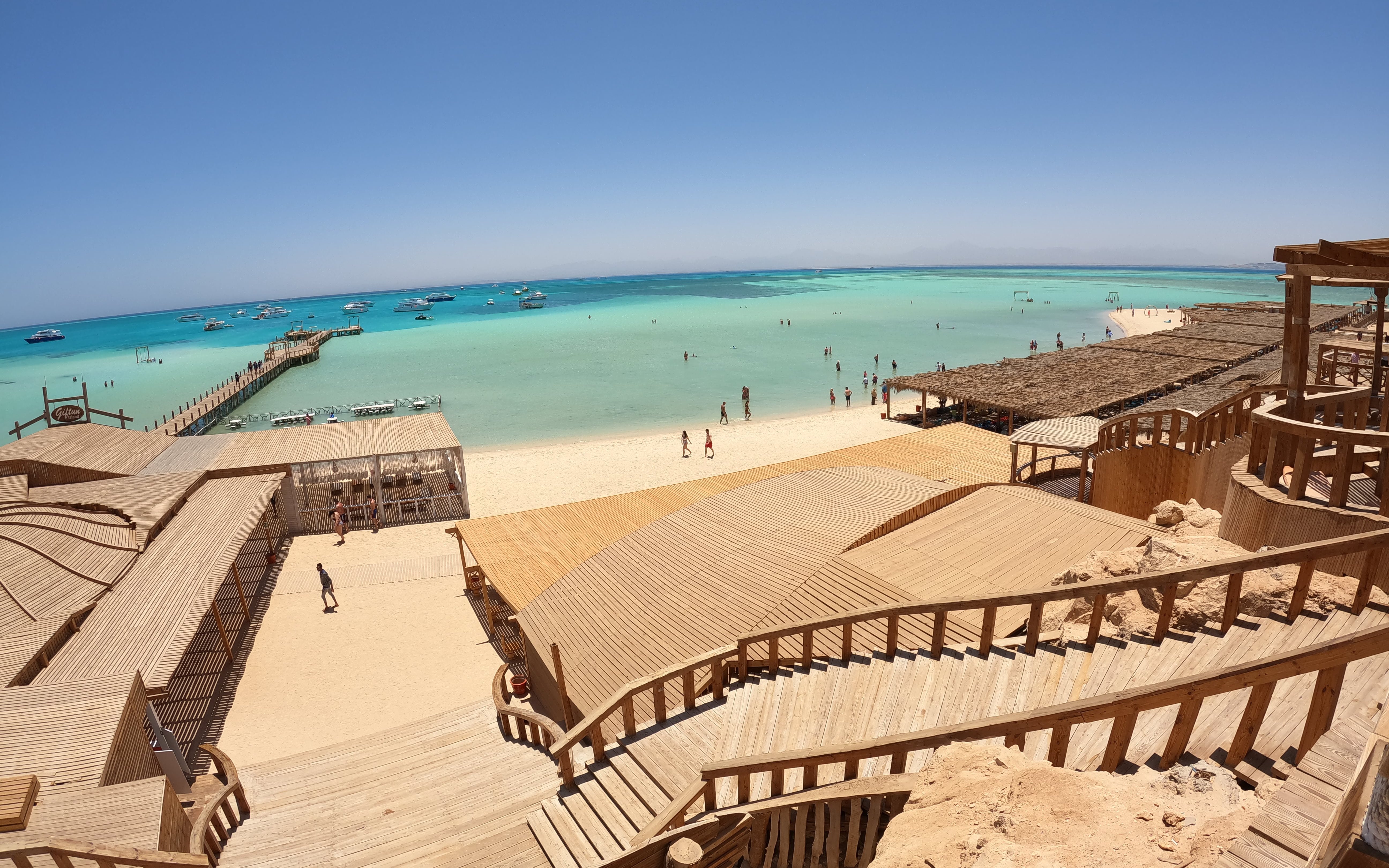 Wooden walkways and beach huts on Orange Bay, Red Sea, near Hurghada, Egypt, with turquoise waters.