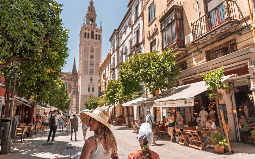 City streets of Sevilla old town with Giralda tower in the background.