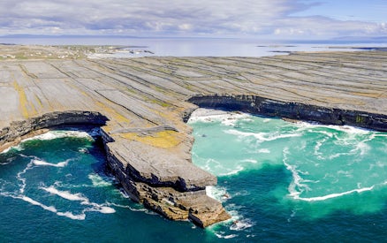 Rugged stone cliffs and turquoise waters of Aran Island, Ireland.