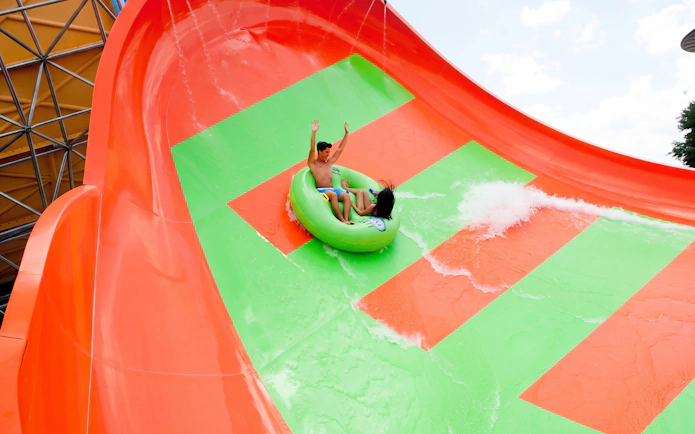 Riders on Tsunami Surge water slide at Hurricane Harbor Arlington.