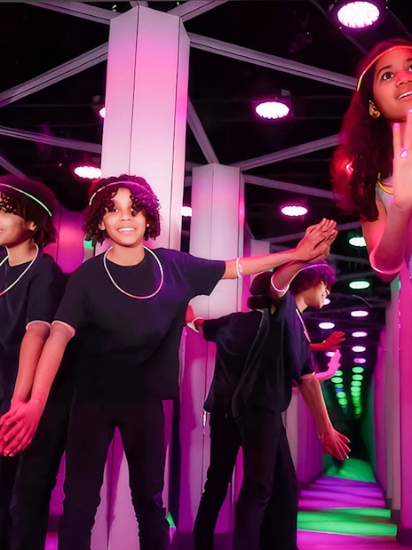 Kids exploring Mirror Maze at American Dream, surrounded by colorful reflections.
