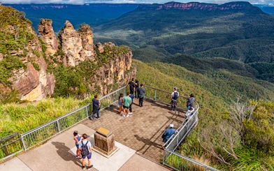 Visitors at Echo Point lookout viewing the Three Sisters rock formation in Blue Mountains, Australia.