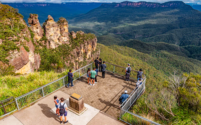 Visitors at Echo Point lookout viewing the Three Sisters rock formation in Blue Mountains, Australia.