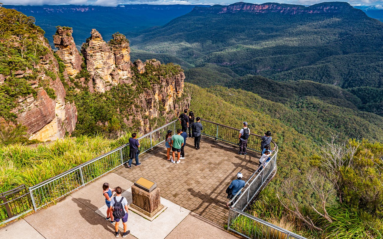 Visitors at Echo Point lookout viewing the Three Sisters rock formation in Blue Mountains, Australia.