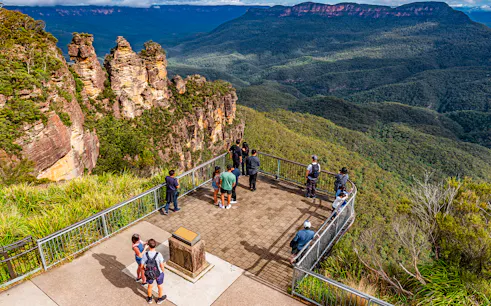 Visitors at Echo Point lookout viewing the Three Sisters rock formation in Blue Mountains, Australia.