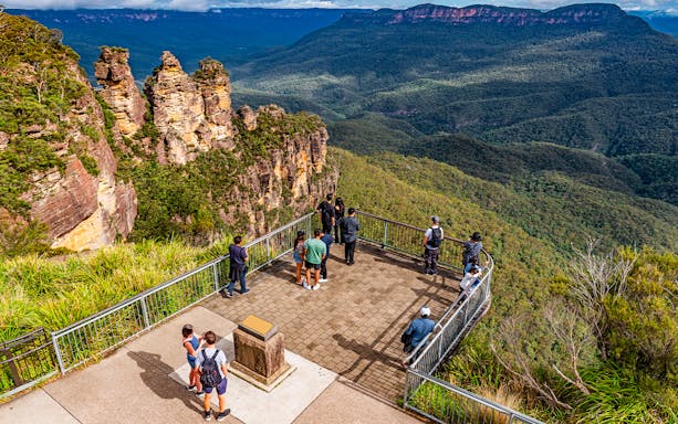 Visitors at Echo Point lookout viewing the Three Sisters rock formation in Blue Mountains, Australia.