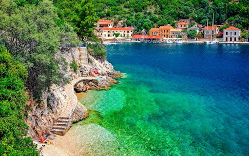 Coastal view of Kioni village, Greece with colorful buildings and clear blue water.