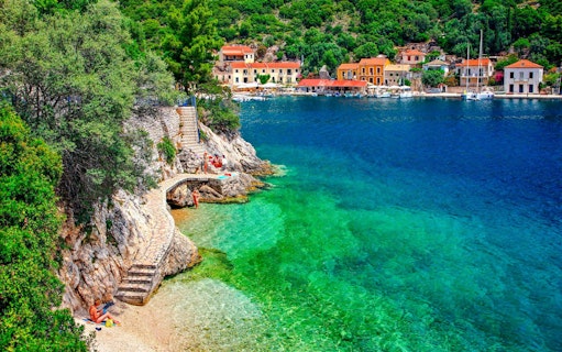 Coastal view of Kioni village, Greece with colorful buildings and clear blue water.