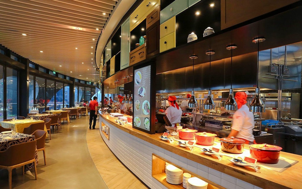 Revolving Restaurant interior at Oriental Pearl Tower, Shanghai, featuring chefs and dining area.