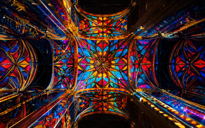 Stained glass ceiling of Westminster Cathedral, London, illuminated in vibrant colors.