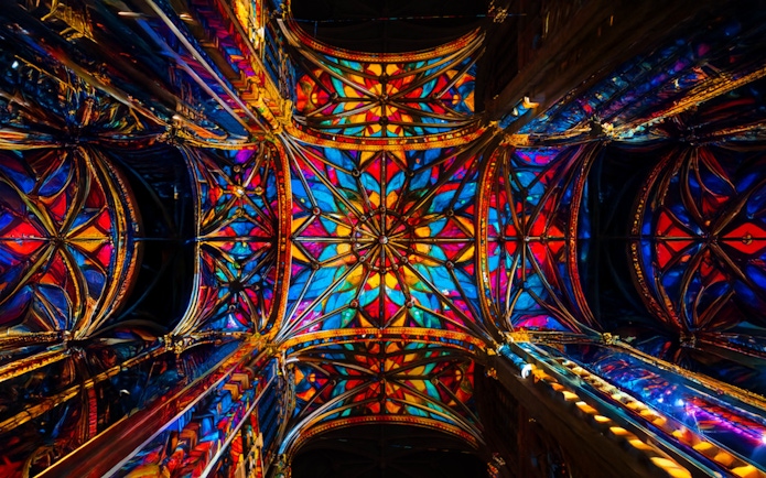 Stained glass ceiling of Westminster Cathedral, London, illuminated in vibrant colors.