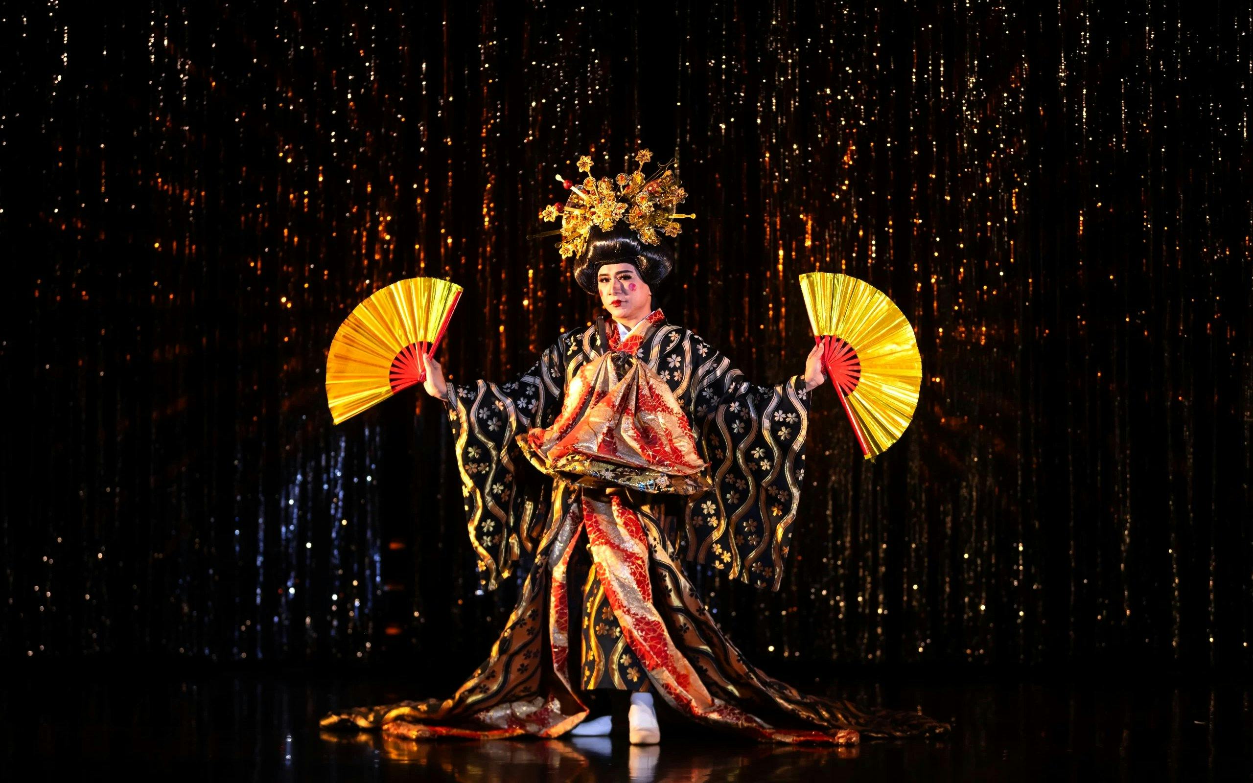 Performer in traditional costume with fans at Calypso Cabaret, Bangkok.