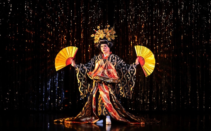 Performer in traditional costume with fans at Calypso Cabaret, Bangkok.