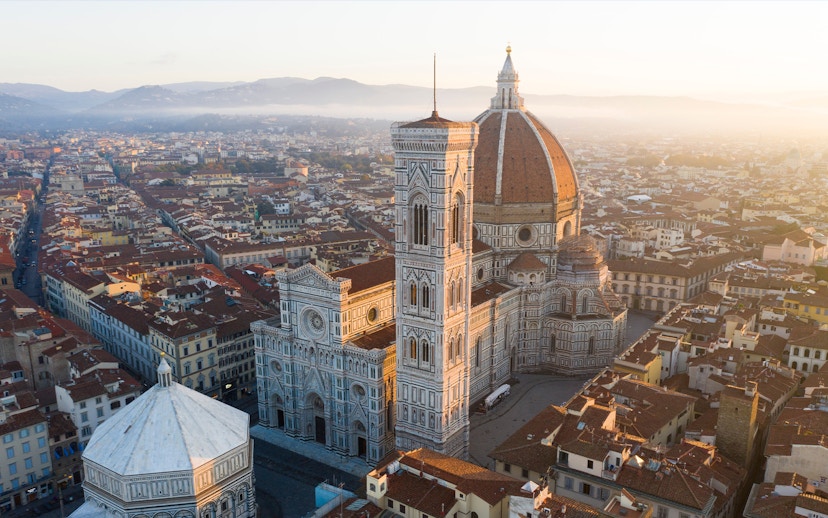 Florence Duomo aerial view with surrounding cityscape at sunrise.