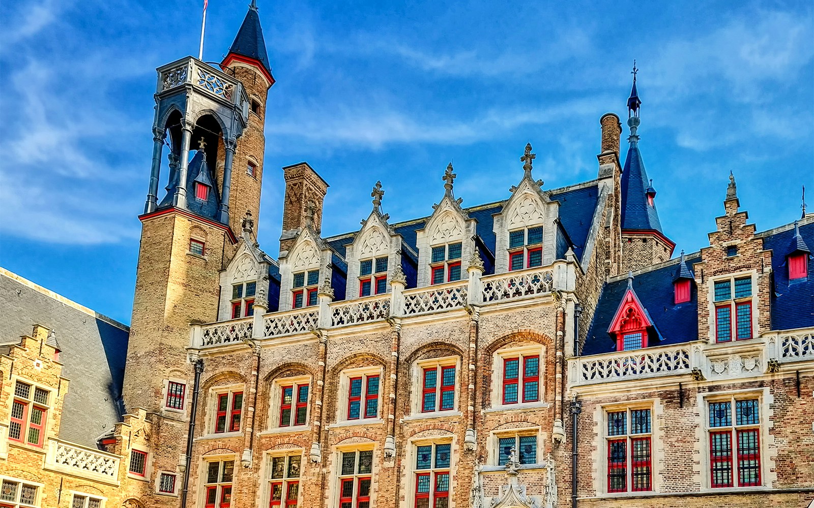 Historic building facade with ornate gables and tower in Bruges, Belgium.