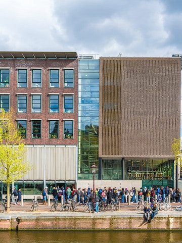 Anne Frank House in Amsterdam with visitors lined up outside.